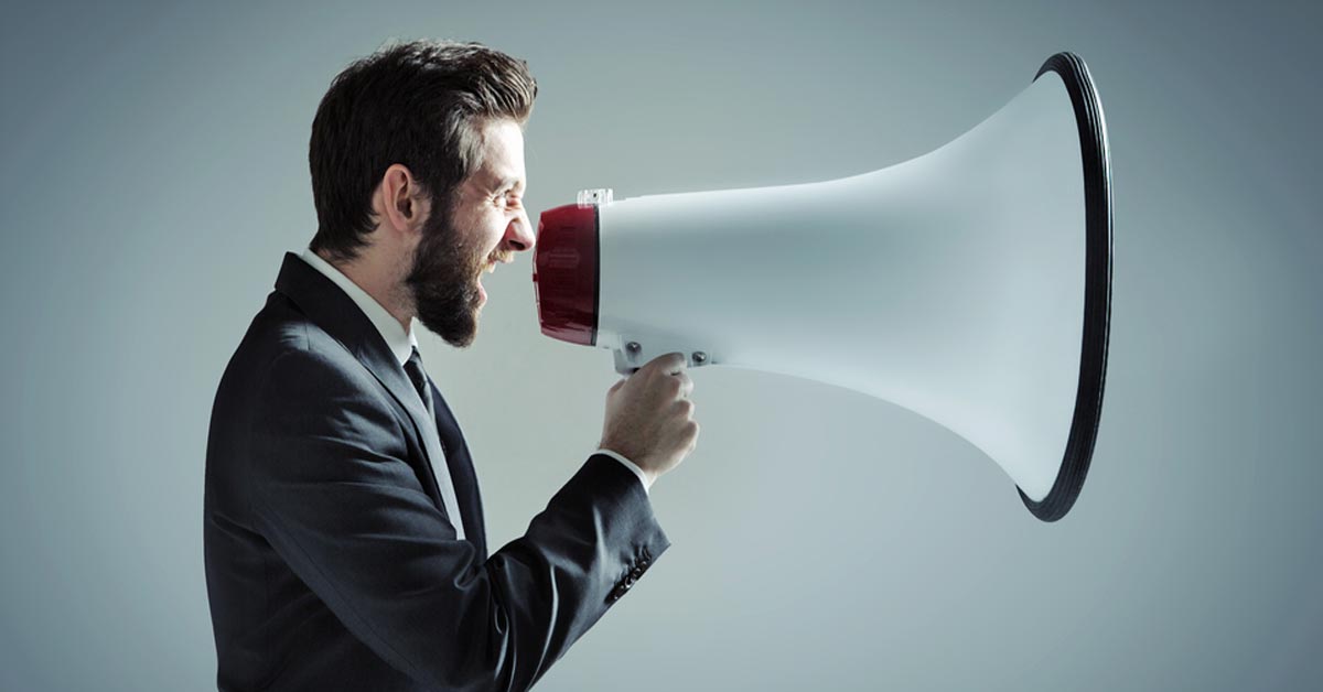 Man in suit yelling into giant megaphone